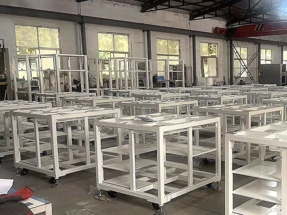 Rows of white metal frames in a workshop