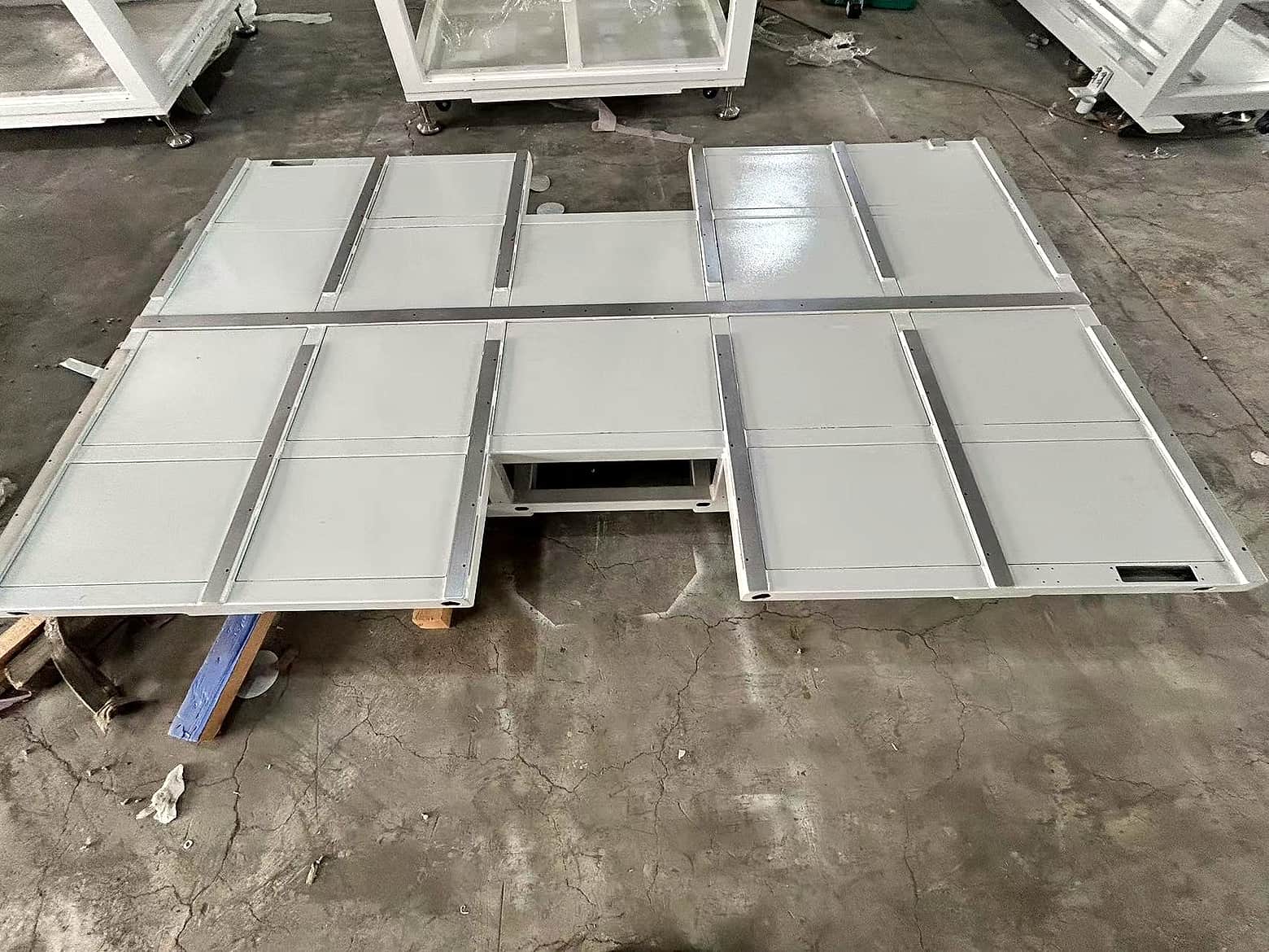 White metal panels laid out on a workshop floor